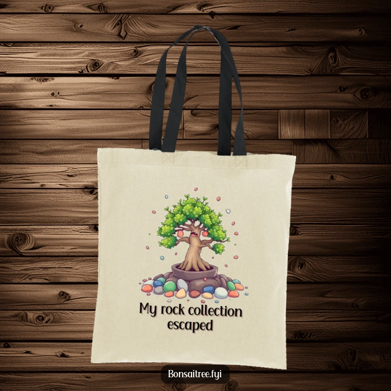 Funny tote bag featuring a giggling bonsai tree character spilling small painted stones. A cheerful and amusing accessory.